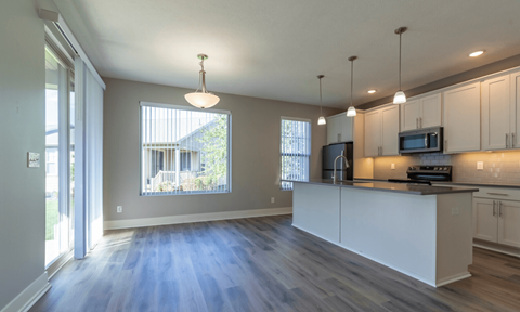 A kitchen with white cabinets and a large island.