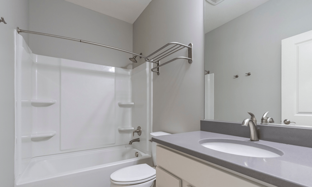 A white bathroom with a toilet, sink, and shower.