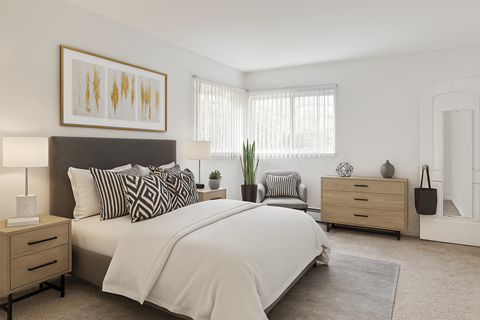 A bedroom with a large bed, a nightstand, and a dresser.