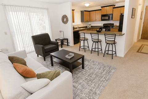 A living room with a white couch and a black chair.
