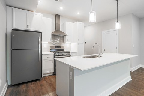 a white kitchen with stainless steel appliances and a white counter top