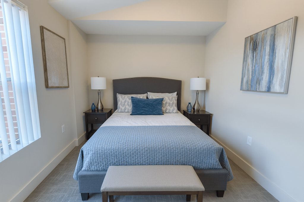 A bedroom with a large bed and a painting on the wall.