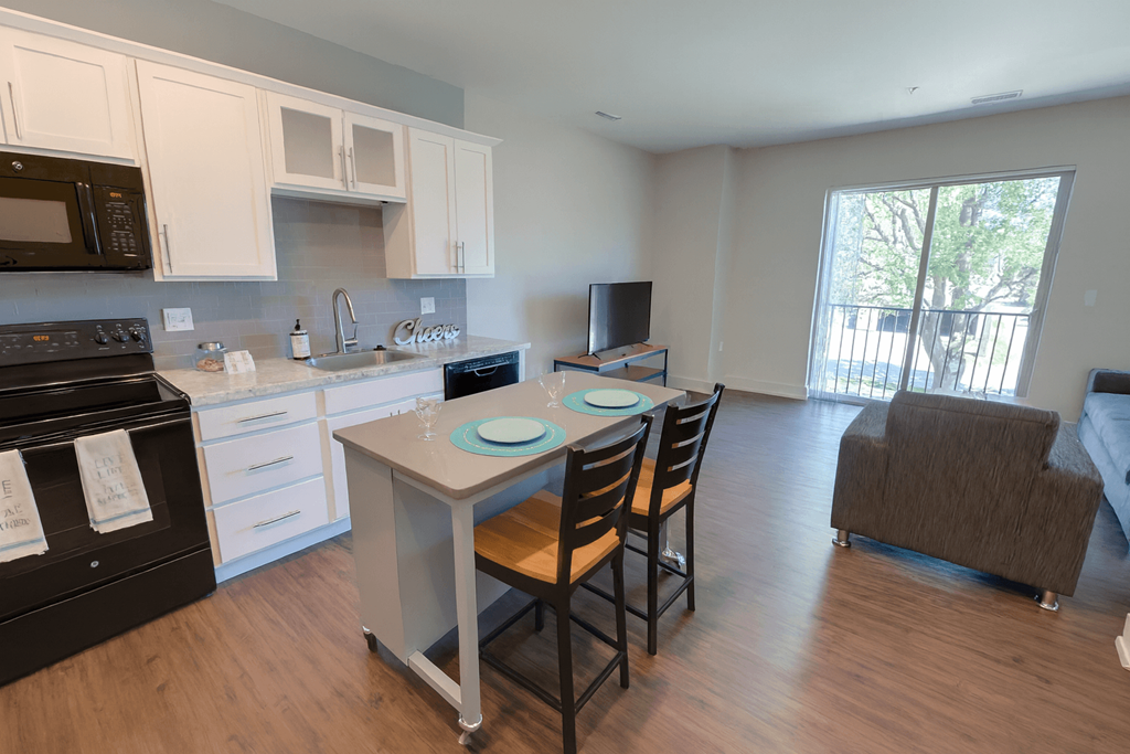 A kitchen with black appliances and white cabinets.