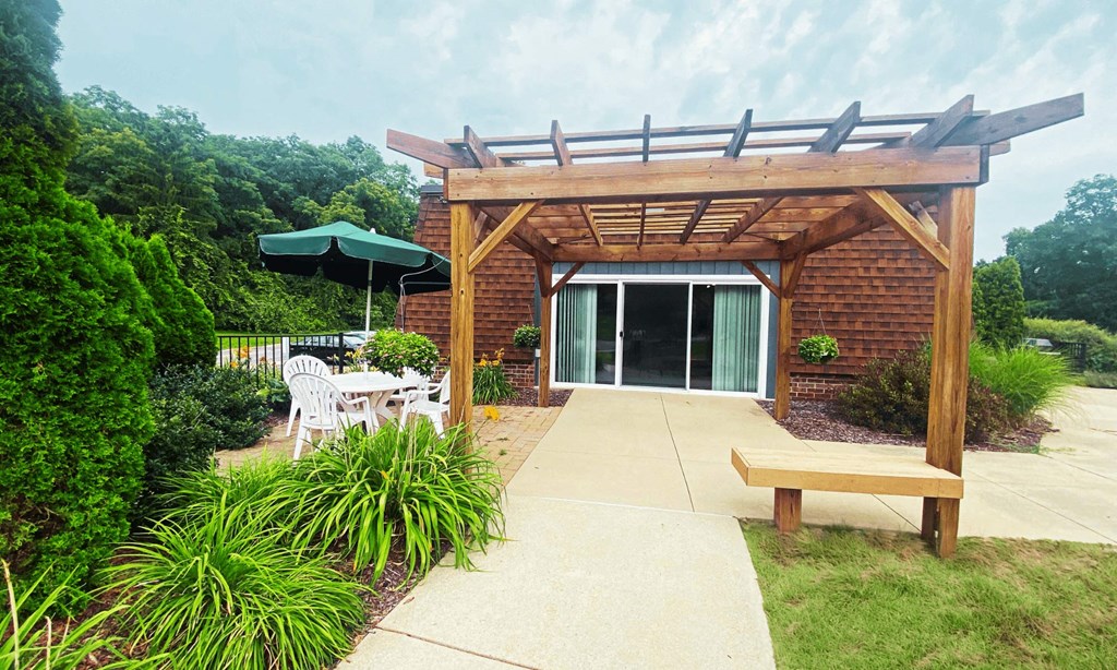 A wooden pergola with a bench at Briarlane Apartments in Grand Rapids, MI