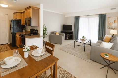 A well-lit, modern living room with a dining table set for two.