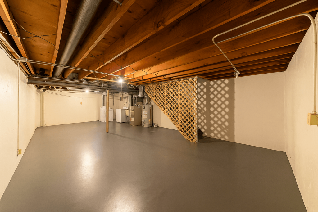 A large empty room with a wooden ceiling and a metal staircase.