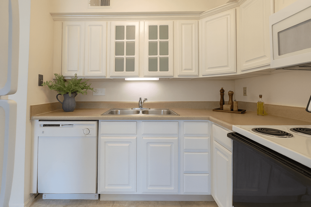 A white kitchen with a black stove top oven.