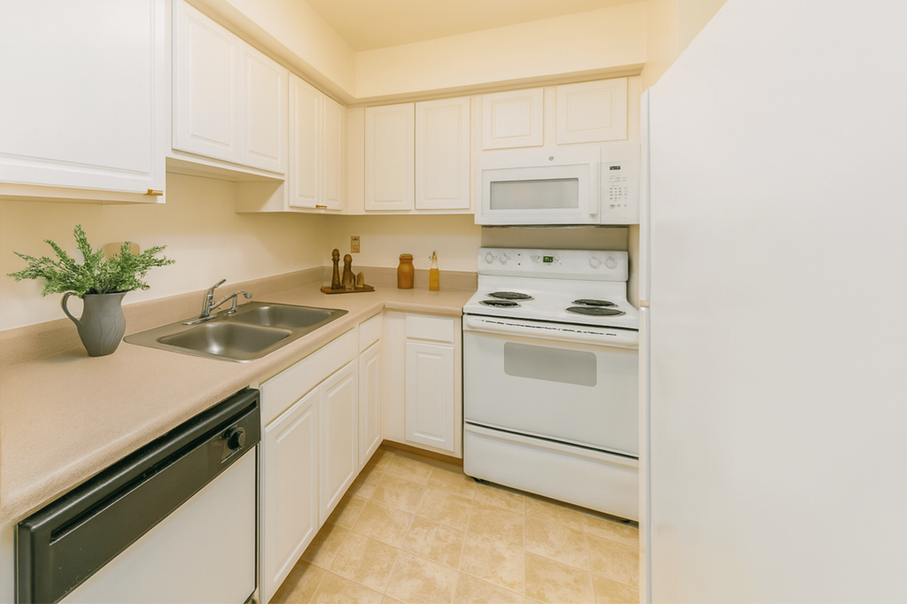 A kitchen with white appliances and cabinets.