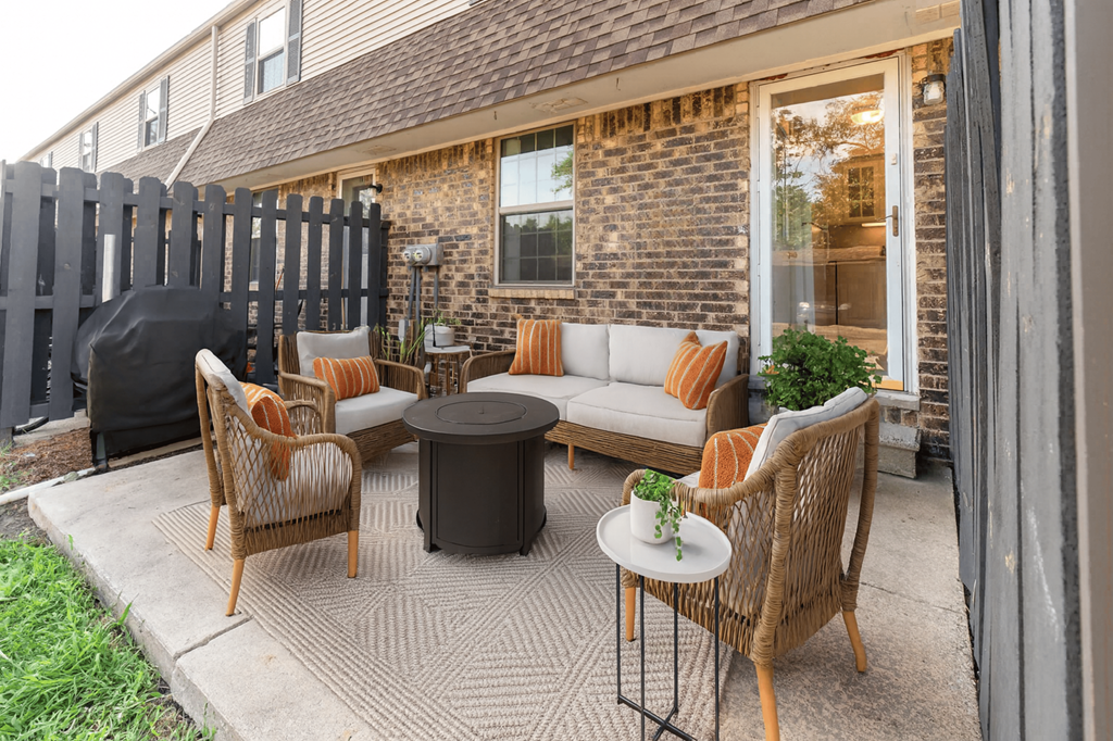 A patio with a table and chairs is set up outside a house.