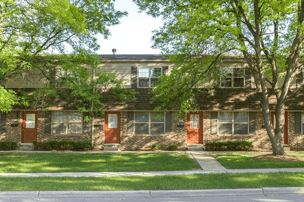 A building with a green tree in front of it.