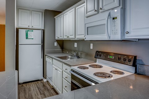 a kitchen with white cabinets and appliances and a white refrigerator