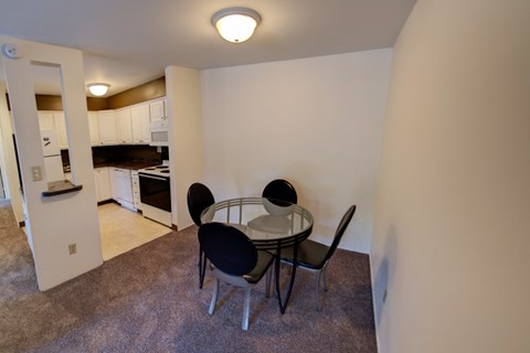 a dining room with a table and chairs and a kitchen