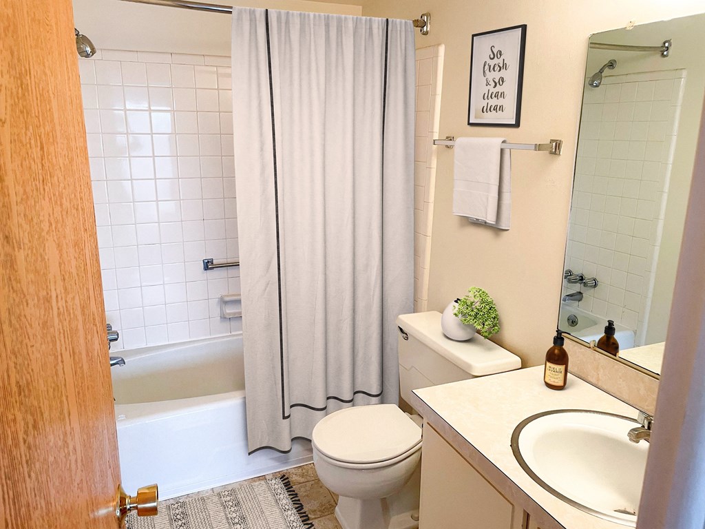 a bathroom with a sink toilet and tub and a shower curtain