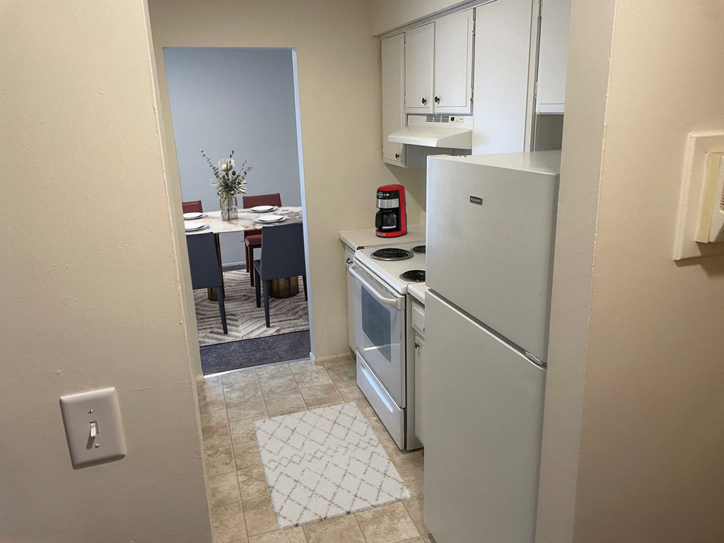 a kitchen with a refrigerator and a stove and a dining room