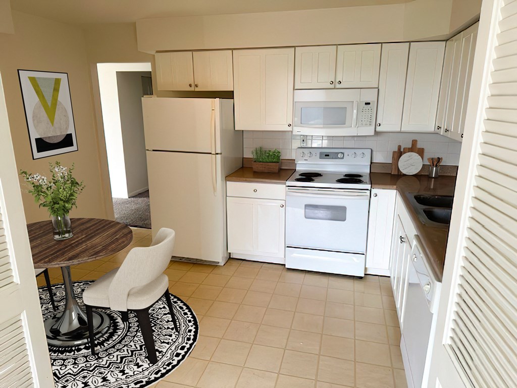 a kitchen with white appliances and a dining room table