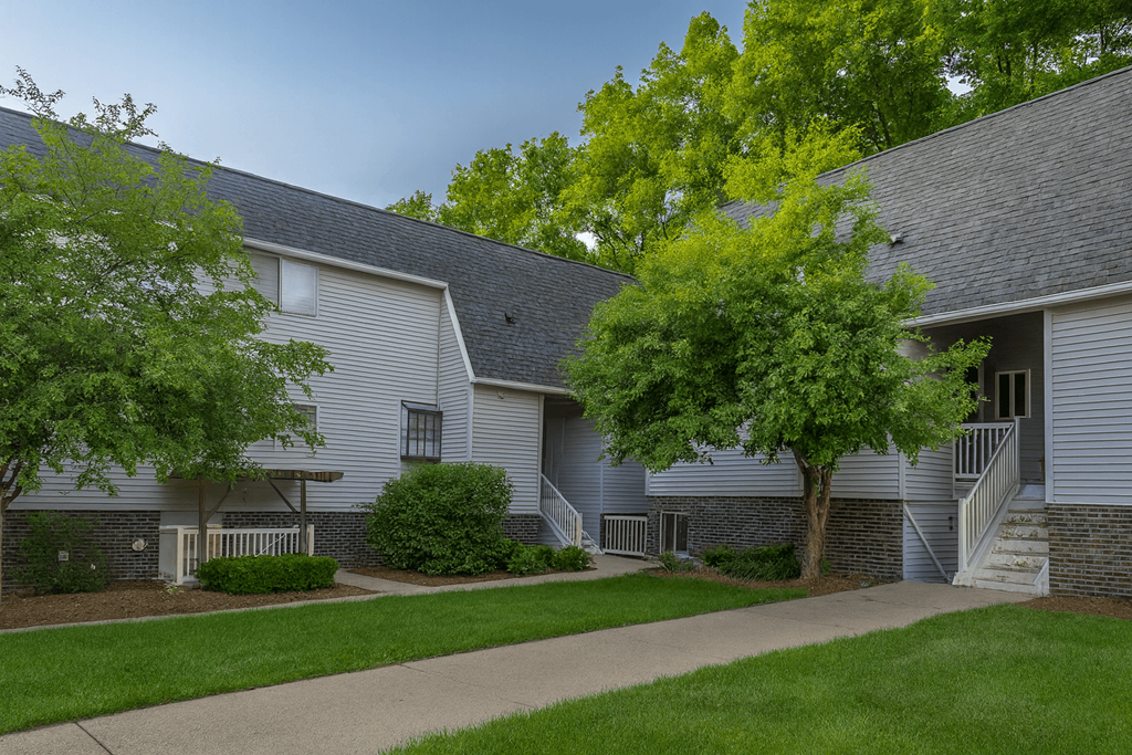 A grey building with a tree in front.
