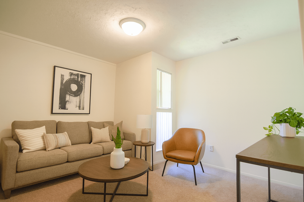 A living room with a couch, chair, and table.