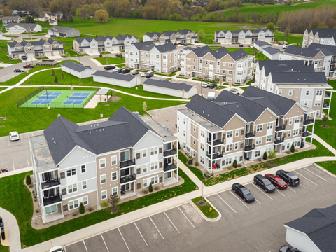 A large apartment complex with a pool and tennis court.
