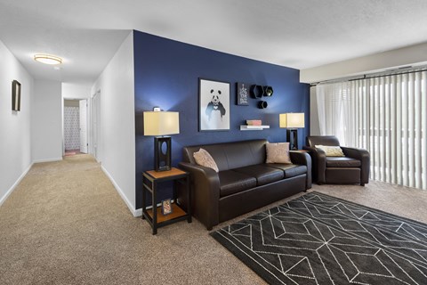 a living room with a blue accent wall and leather furniture