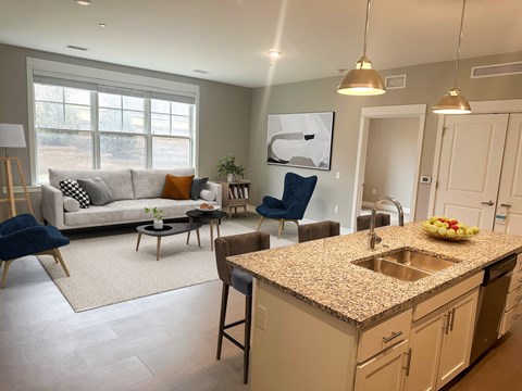 a living room and kitchen with a granite counter top