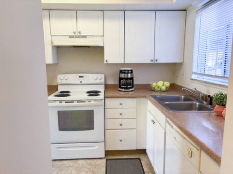 a kitchen with white appliances and white cabinets
