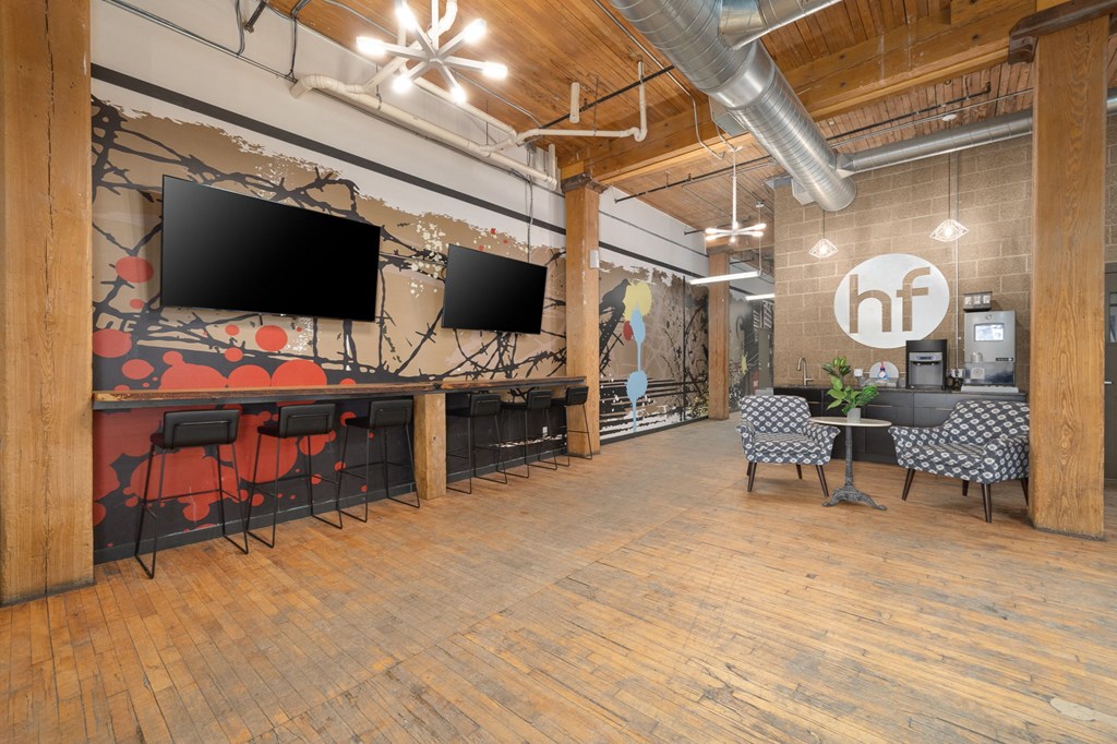 a large open space with wood floors and a mural on the wall