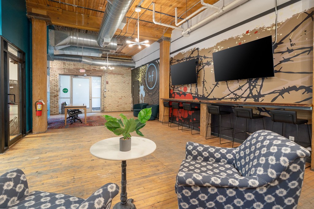 a room with two blue and white chairs and a table with a potted plant
