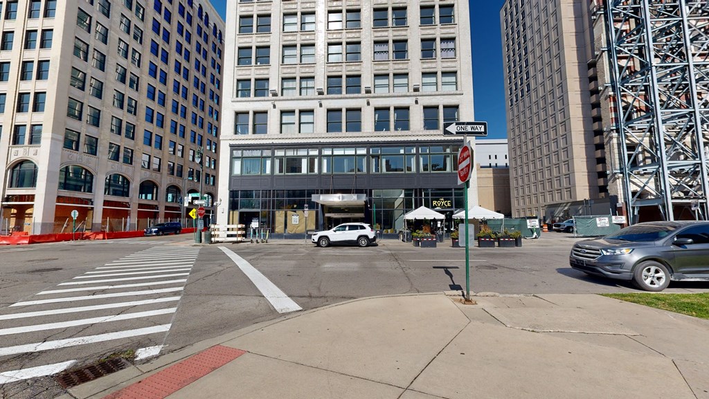 a view of a street corner in a large city with a building in the background