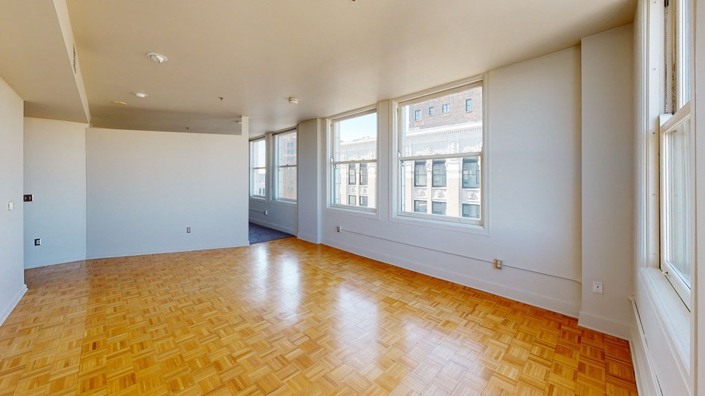a living room with white walls and a wood floor