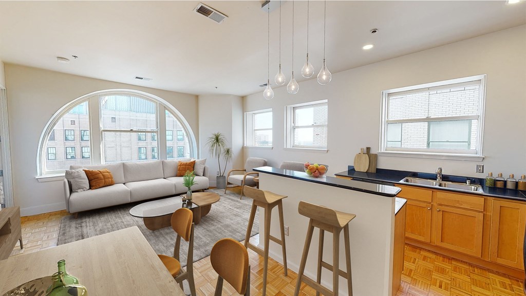 a living room and kitchen with a large arched window