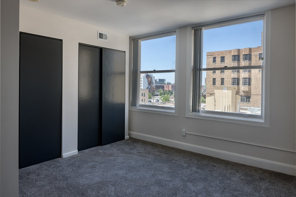 an empty room with a window and three doors