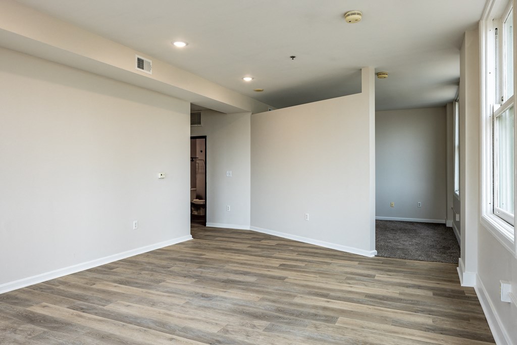a living room with white walls and a wooden floor