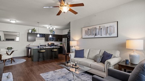 A modern living room with a bar area and a kitchen in the background.