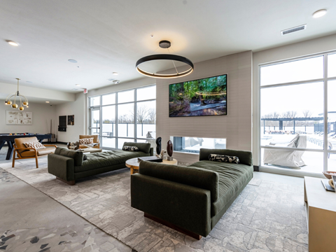 A living room with a large couch and a television mounted on the wall.