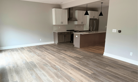 A kitchen with wooden floors and white walls.