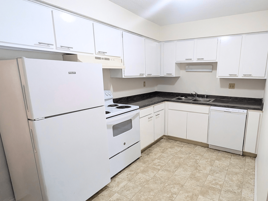 A kitchen with white appliances and cabinets.