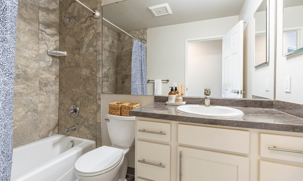 A bathroom with a white tub, toilet, and sink.