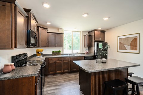an updated kitchen with dark wood cabinets and granite counter tops