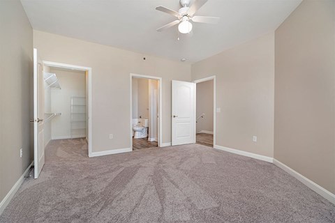 an empty bedroom with a ceiling fan