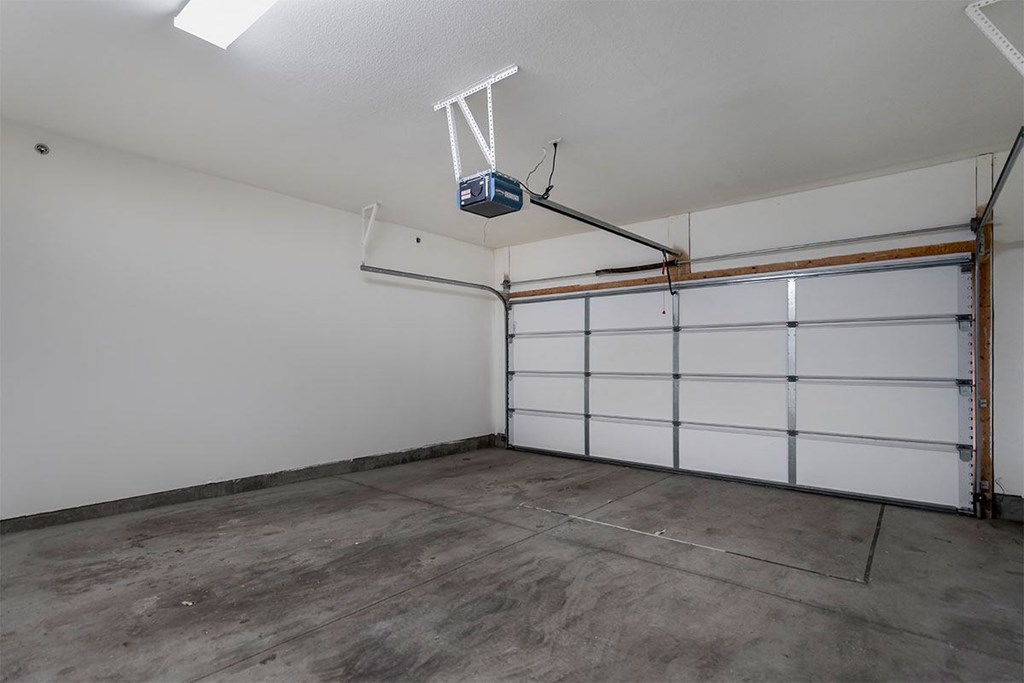 the interior of a garage with white walls and a concrete floor