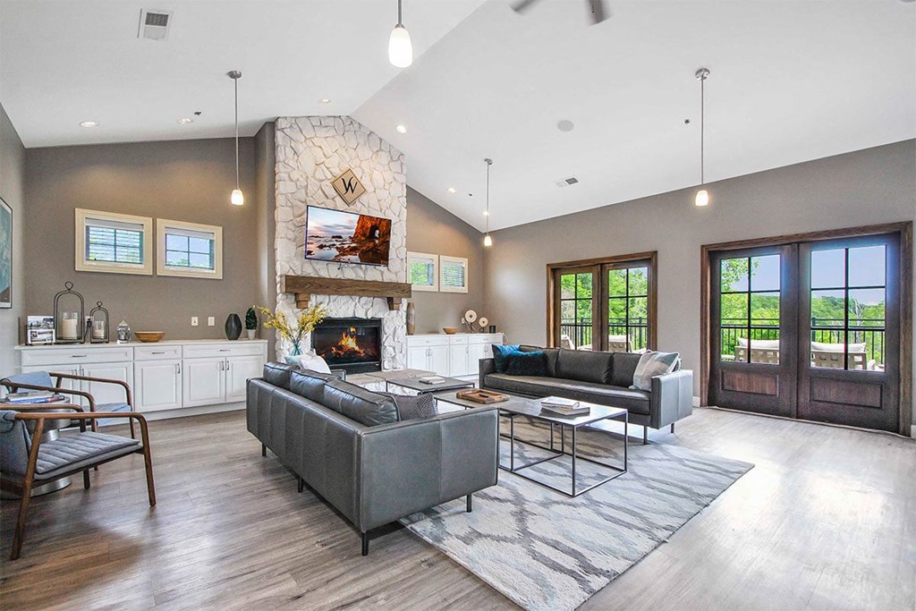 a living room with couches and a coffee table in front of a fireplace