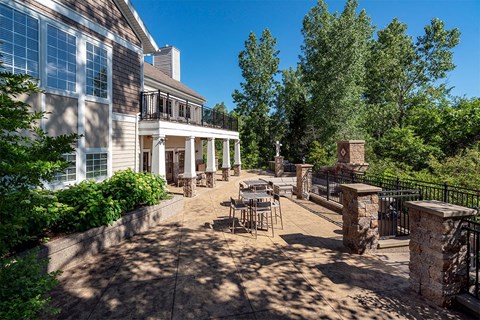 a patio with tables and chairs in front of a building