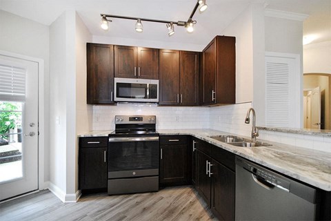 a kitchen with black cabinets and stainless steel appliances
