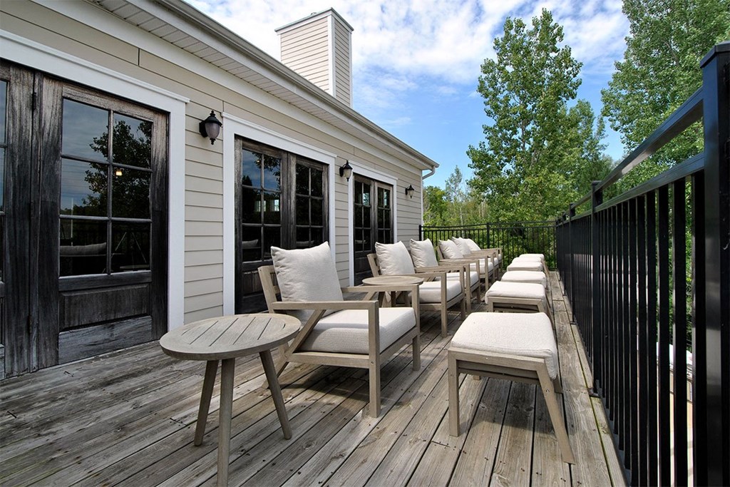 a deck with chairs and stools on a sunny day