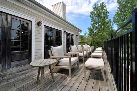 a deck with chairs and stools on a sunny day