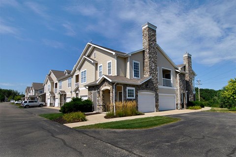 a house with a stone chimney and a white garage door