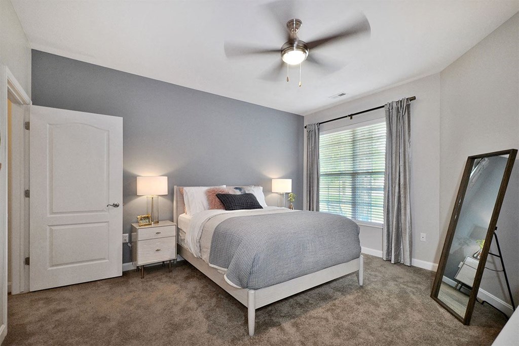 a bedroom with a bed and a ceiling fan