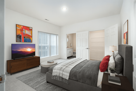 A bedroom with a large bed and a flat screen TV.