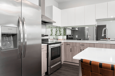 A modern kitchen with a stainless steel refrigerator and a white countertop.