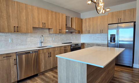 A kitchen with wooden cabinets and a white island.